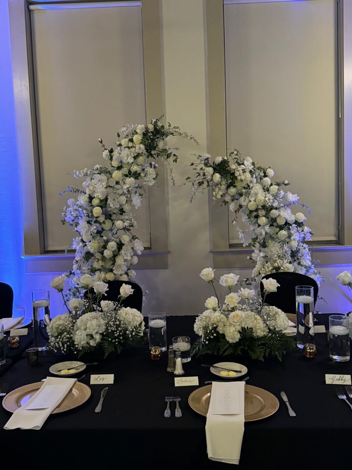 White floral arch pair framing a reception table
