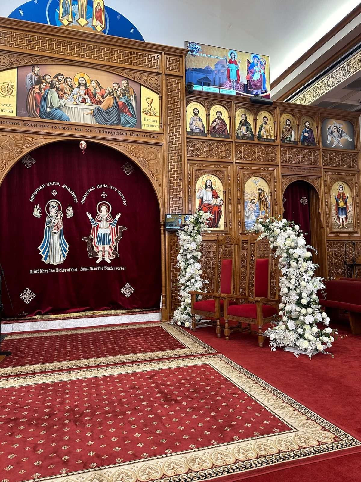 White floral arch pair framing a church ceremony setting