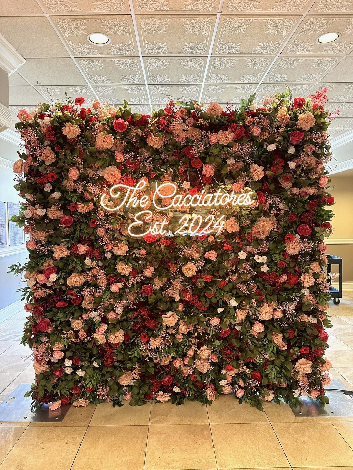 Red and blush flower wall with a custom graduation sign