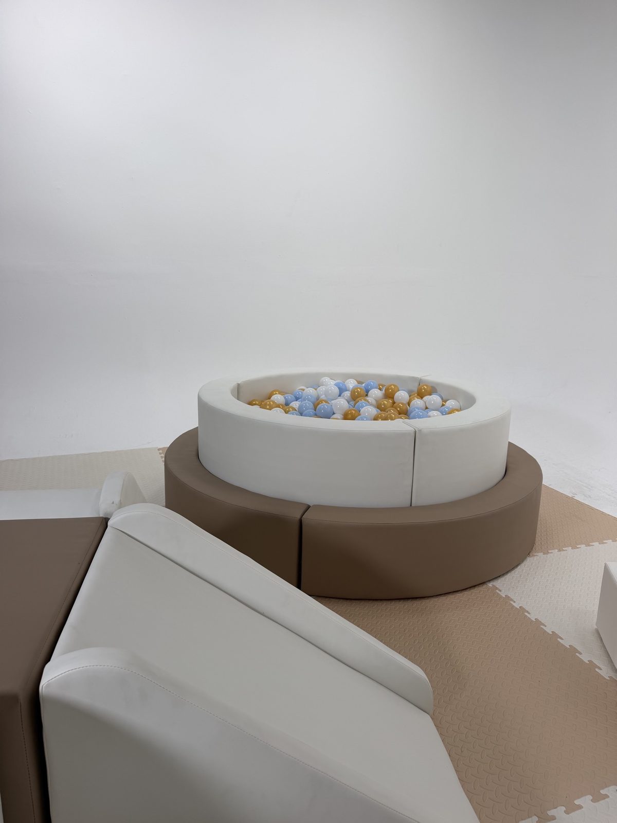 Neutral soft-play slide and raised ball pit