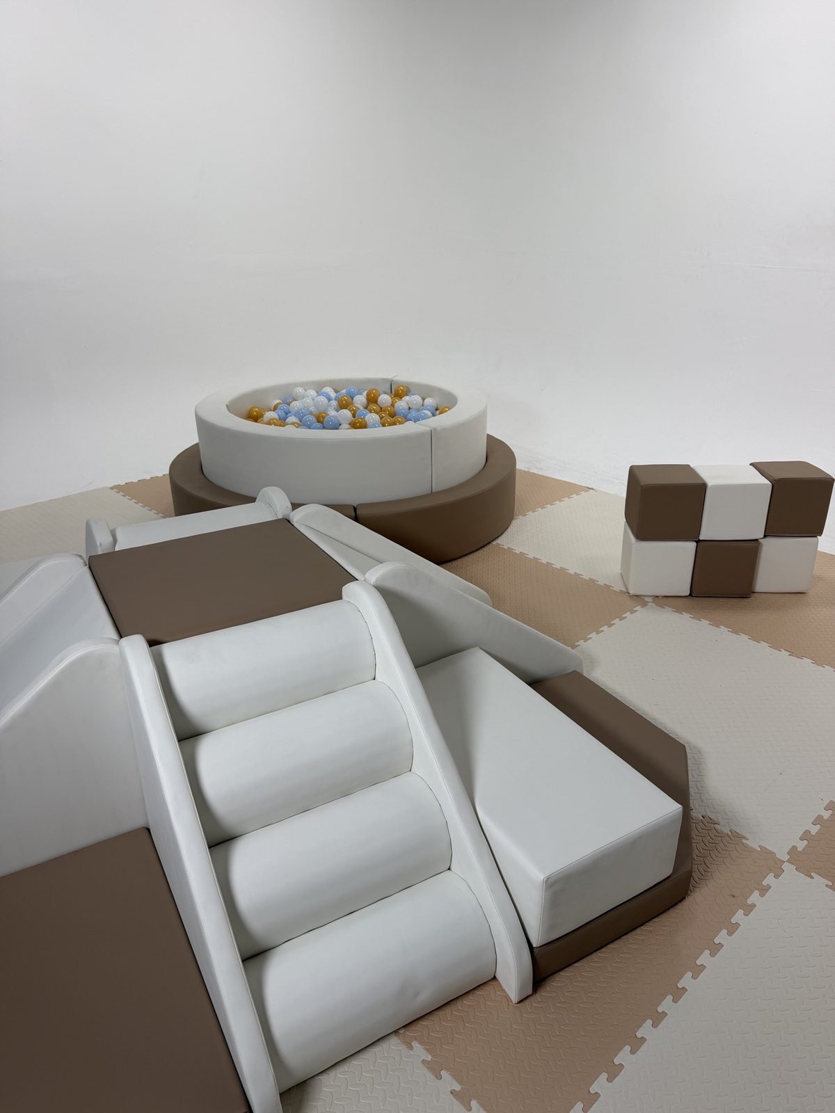 Soft-play ball pit and climbing pieces arranged inside the fence